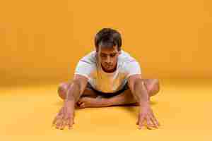 Kostenloses Foto junger mann, der yogaübung tut