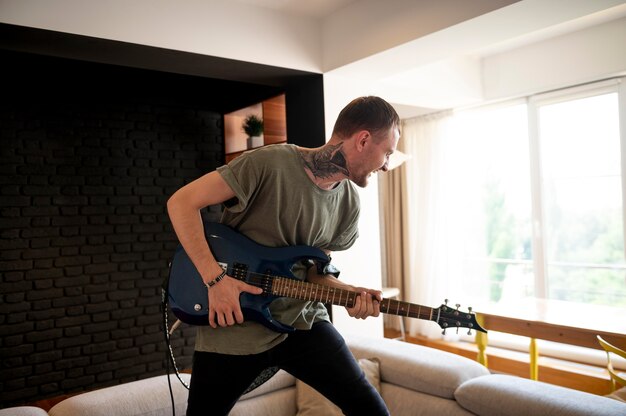 Junger Mann, der zu Hause Gitarre spielt