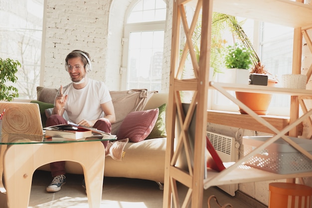 Kostenloses Foto junger mann, der zu hause während der online-kurse studiert