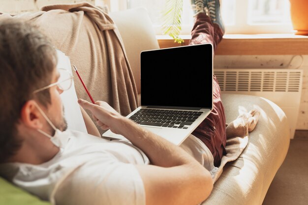 Junger Mann, der zu Hause während der Online-Kurse studiert