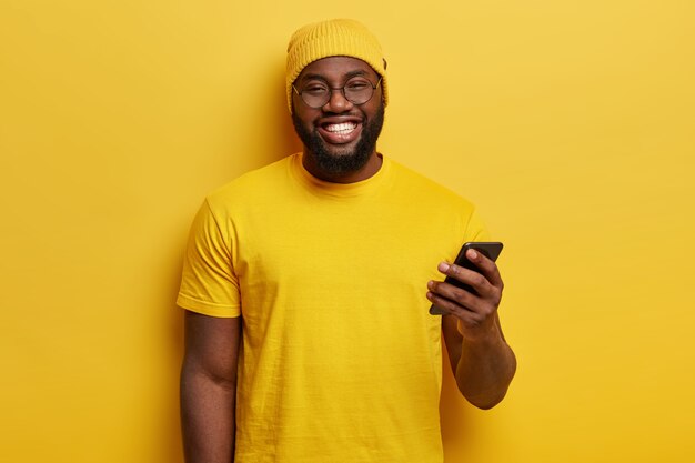 Junger Mann gekleidet in gelbem Haltetelefon