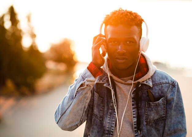 Junger Mann in hörender Musik der Stadt