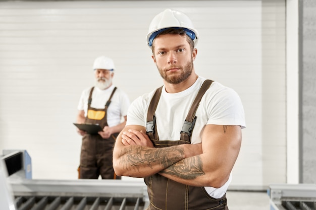 Junger Mann in Uniform und Helm auf Metallfabrik