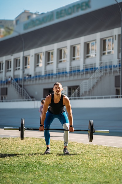 Kostenloses Foto junger mann legt die messlatte im stadion höher, training im freien