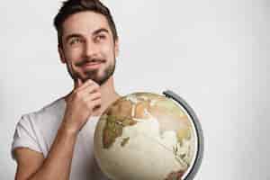 Kostenloses Foto junger mann mit bart und globus