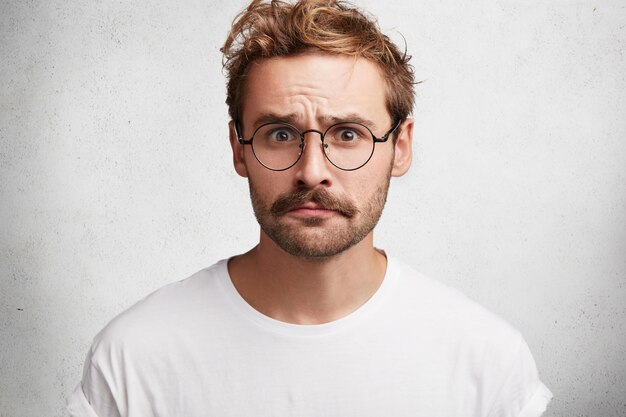 Junger Mann mit Bart und runder Brille