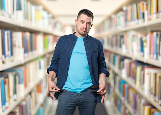 Junger Mann mit einem blauen Outfit tragen. Doing Geld weniger Geste.