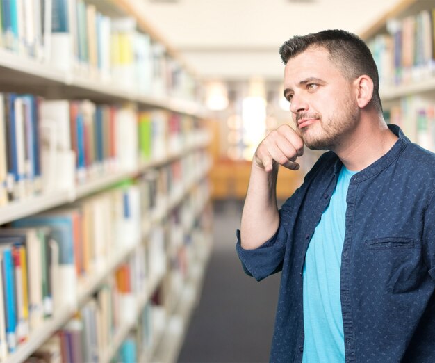 Junger Mann mit einem blauen Outfit tragen. Doing Telefon Geste.