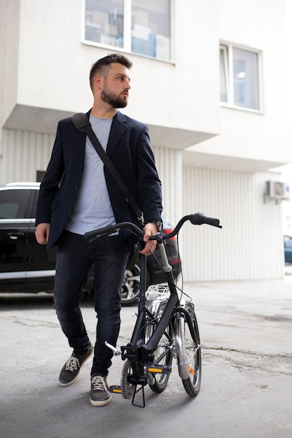 Kostenloses Foto junger mann mit einem klapprad in der stadt