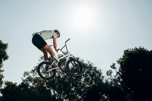 Junger Mann mit Fahrrad hoch springen