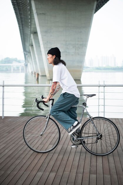 Junger Mann mit Fahrrad in der Stadt