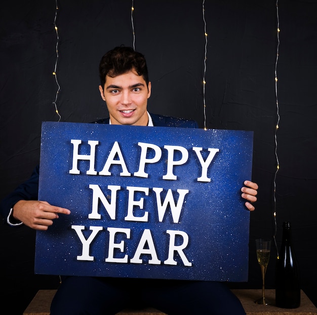 Junger Mann mit großer blauer Tablette mit Aufschrift