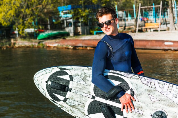 Junger Mann mit Kitesurfbrett