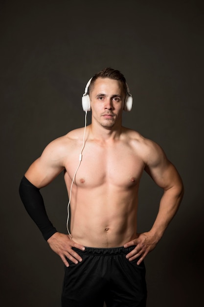 Junger Mann mit Kopfhörern im Fitnessstudio