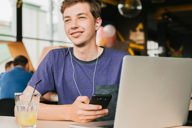 Junger Mann mit Laptop und Kopfhörern