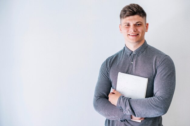 Junger Mann mit Notizbuch im Studio