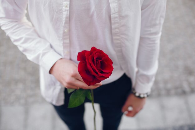 junger Mann mit Rose