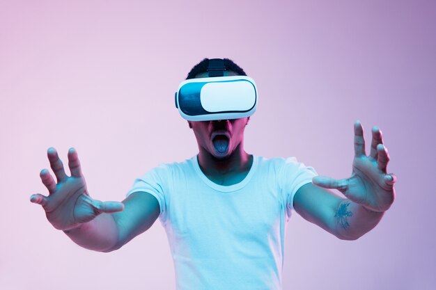 Junger Mann mit VR-Brille mit Neonlichtern