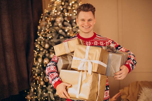 Junger Mann mit Weihnachtsgeschenken