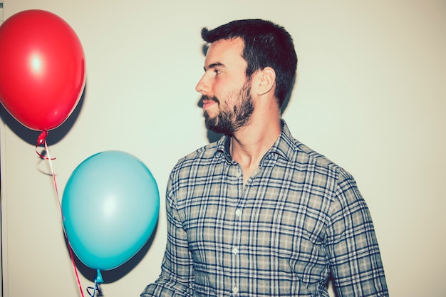 Kostenloses Foto junger mann posiert mit luftballons