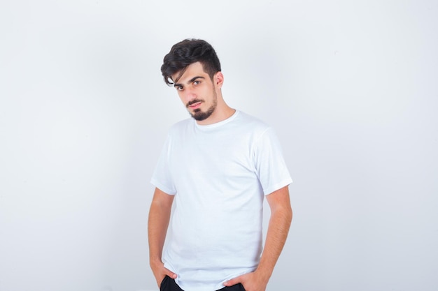 Junger Mann posiert, während er im T-Shirt steht und selbstbewusst aussieht