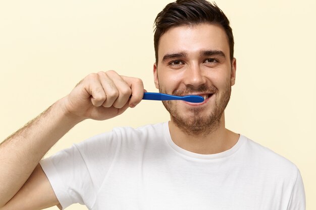 Junger Mann putzt sich die Zähne