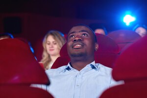 Junger mann schaut sich im kino einen film an