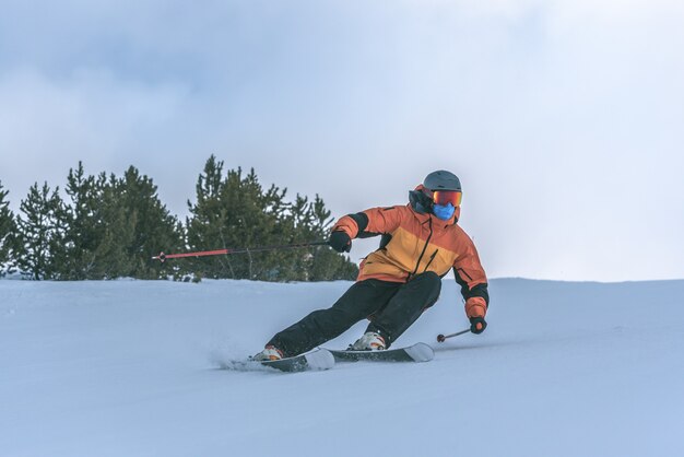 Junger Mann Skifahren in den Pyrenäen im Skigebiet Grandvalira