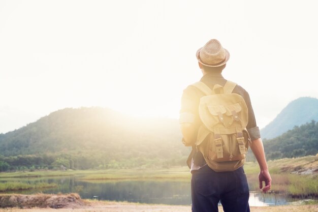 Junger Mann Traveller mit Rucksack entspannenden Outdoor.