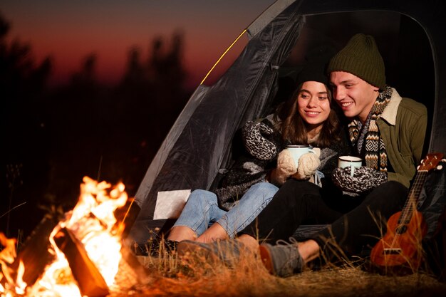 Junger Mann und Frau, die ein Feuer genießt