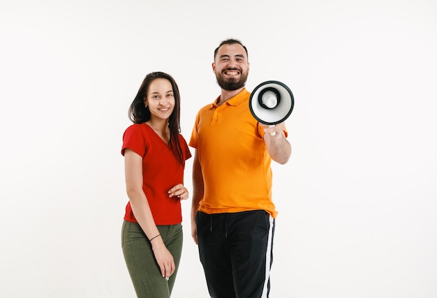 Junger Mann und Frau mit lebendigen T-Shirts und Megaphon