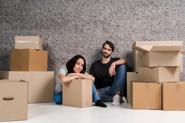 Junger Mann und junge Frau bereiten Kisten für Umzug vor