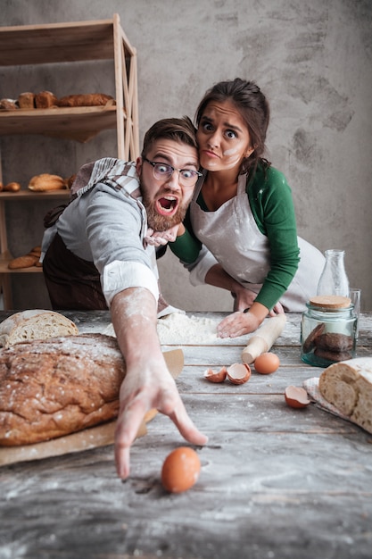 Junger Mann und junge Frau, die versuchen, Ei zu fangen