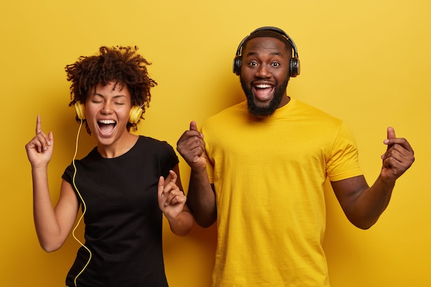 Junger Mann und junge Frau hören Musik in Kopfhörern