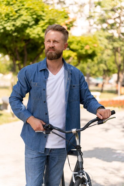 Junger Mann verbringt Zeit draußen mit seinem Fahrrad