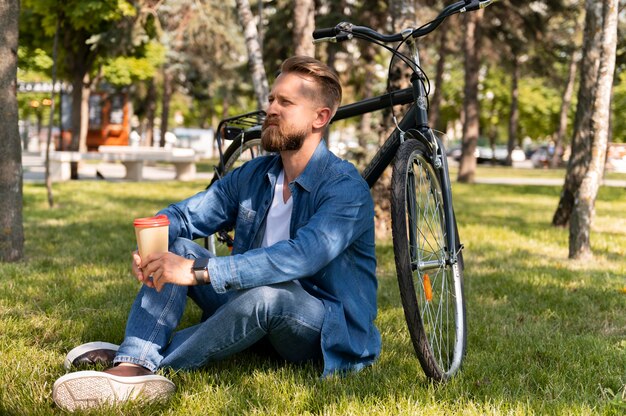 Junger Mann verbringt Zeit draußen mit seinem Fahrrad