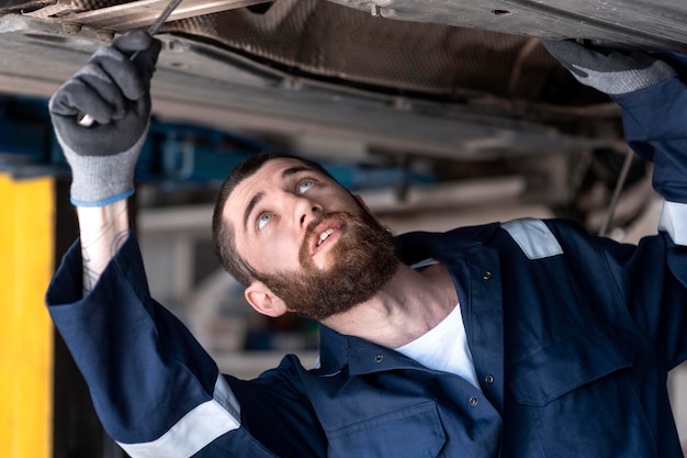 Junger Mechaniker, der in seiner Werkstatt arbeitet