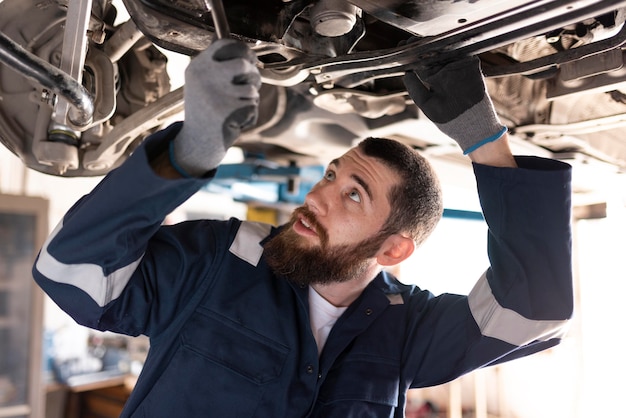 Junger Mechaniker, der in seiner Werkstatt arbeitet