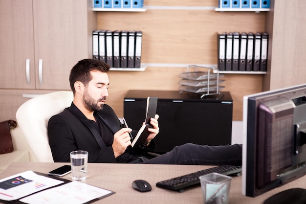 Junger müder Geschäftsmann, der in seinem Büro arbeitet. Kaufmann im beruflichen Umfeld