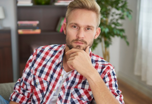 Kostenloses Foto junger nachdenklicher mann in seinem wohnzimmer