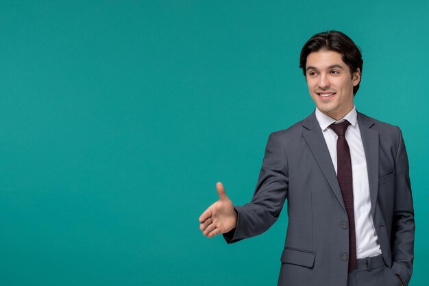 Junger netter gutaussehender Mann des Geschäftsmannes im grauen Büroanzug und -krawatte, die Händedruck geben