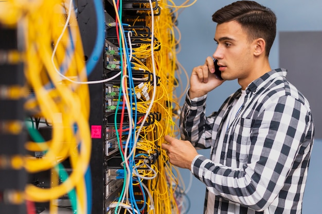 Kostenloses Foto junger netzingenieur, der am telefon spricht