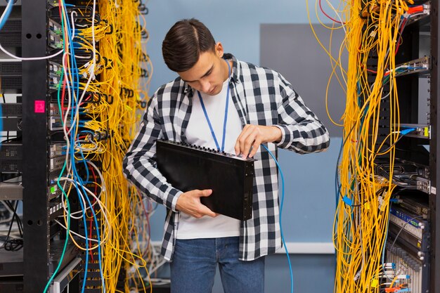 Junger Netzingenieur, der Ethernet-Schalter hält