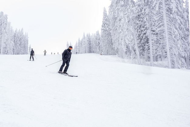 Junger Skifahrer in Bewegung in einem Bergskigebiet mit einer wunderschönen Winterlandschaft im Hintergrund