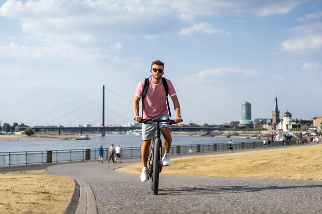 Junger Sportmann auf einem Fahrrad in einer europäischen Stadt. Sport in urbanen Umgebungen.