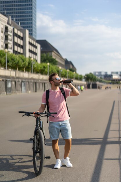 Junger Sportmann auf einem Fahrrad in einer europäischen Stadt. Sport in urbanen Umgebungen.