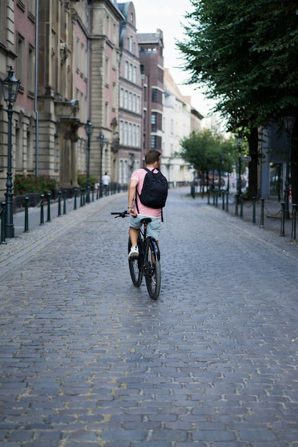 Junger Sportmann auf einem Fahrrad in einer europäischen Stadt. Sport in urbanen Umgebungen.