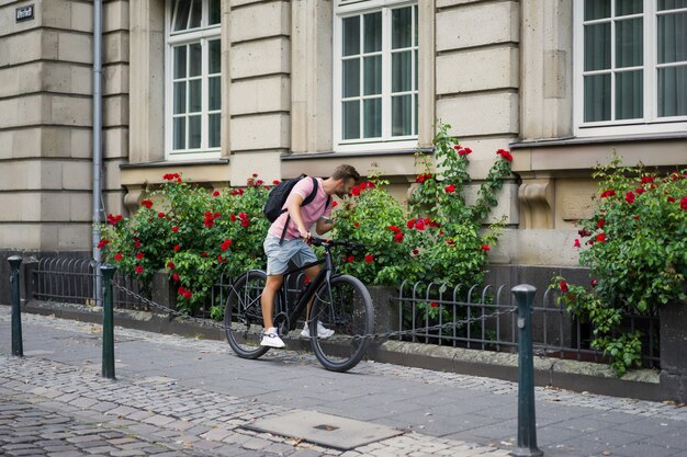 Junger Sportmann auf einem Fahrrad in einer europäischen Stadt. Sport in urbanen Umgebungen.