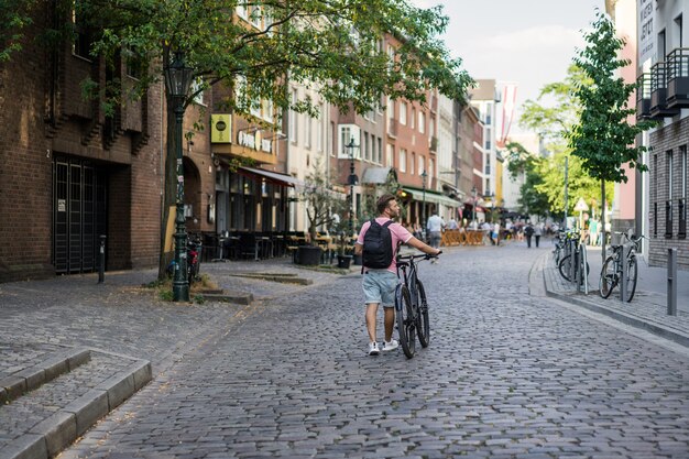 Junger Sportmann auf einem Fahrrad in einer europäischen Stadt. Sport in urbanen Umgebungen.