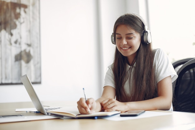 Junger Student, der am Tisch sitzt und den Laptop benutzt